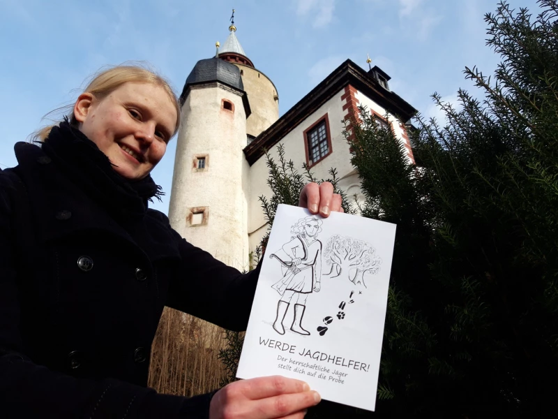 Neues Ferien-Rätsel auf Burg Posterstein | Franziska Huberty aus dem Museum Burg Posterstein mit dem Winterferien-Rätsel vor der Burg Posterstein.