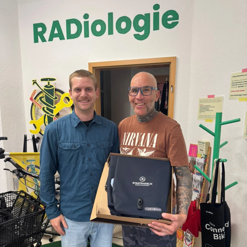 STADTRADELN: 172 Teilnehmende fahren mehr als 37.000 Kilometer | Klimaschutzbeauftragter Philip Stöcker (links) überreicht André Fewgas, Gewinner der Einzelwertung im STADTRADELN, den Preis: eine hochwertige Fahrradtasche.